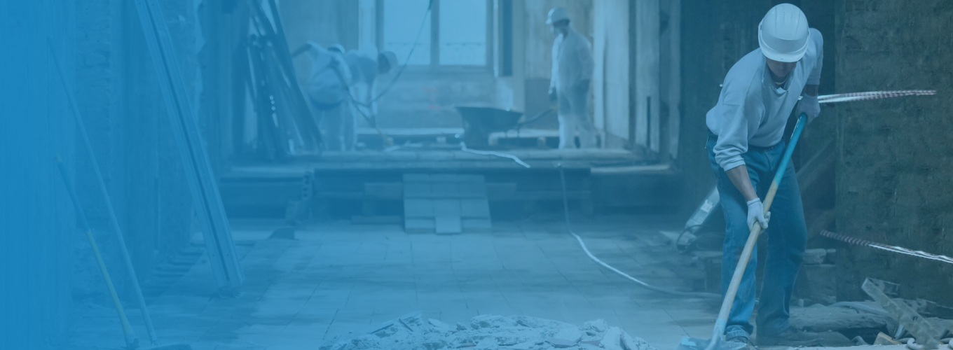 Mitarbeiter räumt Schutt bei einer Demontage zur Seite